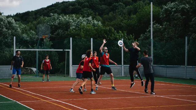 Hráči vyskakujú za frisbee počas zápasu na ihrisku